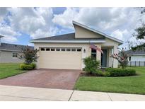 Charming single-story home featuring a brick driveway, two-car garage, and well-manicured landscaping at 3184 Songbird Cir, Harmony, FL 34773