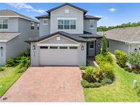 Charming two-story home with brick driveway and landscaped front yard creates instant curb appeal at 3204 Oxbow Ct, St Cloud, FL 34773