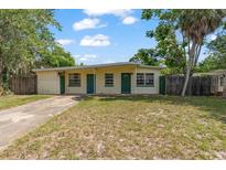 Charming single-story home with a well-maintained lawn and mature trees on a sunny day at 441 Kentia Rd, Casselberry, FL 32707