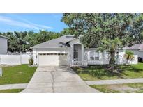 Charming single-story home with a well-maintained front yard, two car garage and quaint white picket fence at 478 Acacia Tree Way, Kissimmee, FL 34758