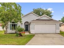 Charming single-story home featuring a well-maintained lawn and an attached two-car garage at 608 Wechsler Cir, Orlando, FL 32824