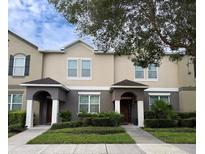 Inviting two-story townhome features neutral paint, manicured landscaping, and covered entryway at 7621 Sutherton Ln, Windermere, FL 34786
