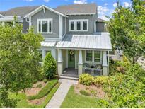 Charming two-story home with landscaped yard, covered porch, and inviting green door at 9121 Laureate Blvd, Orlando, FL 32827