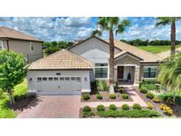 Charming single Gathering home featuring a beautiful tile roof, manicured landscaping, and a two-car garage at 1452 Mickelson Ct, Davenport, FL 33896