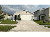 Charming single-story home with a well-manicured lawn and attached two-car garage at 1940 Egret Meadows Ave, Kissimmee, FL 34744