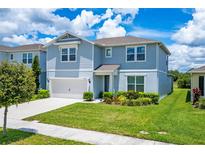 Charming two-story home featuring a well-manicured lawn and beautiful landscaping at 2223 Bluebird Pl, St Cloud, FL 34771