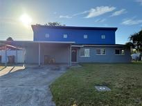 Two-story home featuring a carport and a well-lit exterior with blue and gray paint at 2619 Milton Ave, Kissimmee, FL 34741