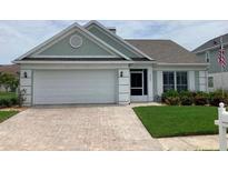 Charming single-story home with a brick driveway and attached two-car garage, plus manicured lawn and garden at 3407 Santa Monica Dr, Orlando, FL 32822