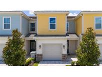 Charming townhouse with a one-car garage, colorful facade, and well-maintained landscaping, creating an inviting curb appeal at 7920 Draw St, Reunion, FL 34747