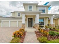 Charming two-story home featuring a welcoming front porch, three-car garage, and well-maintained landscaping at 7971 Brofield Ave, Windermere, FL 34786