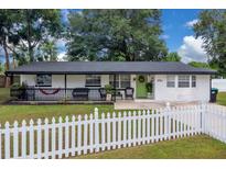Charming single-story home with a white picket fence, front porch and well-manicured lawn at 1710 Thor Ave, Apopka, FL 32703