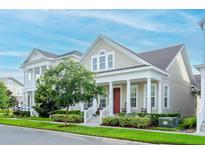 Inviting home featuring a charming front porch, well-maintained landscaping, and a freshly cut lawn at 1855 Treasure Cv, Kissimmee, FL 34747