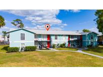 Light blue two-story apartment building featuring red doors and a well-maintained lawn at 1891 Caralee Blvd # 3, Orlando, FL 32822