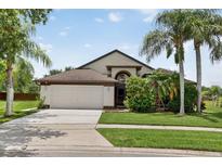 Charming single-story home featuring a two-car garage, landscaped yard, and mature trees at 2612 Keswick Ct, Kissimmee, FL 34744