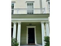 Inviting front entrance featuring stately white columns, a balcony, and dark-colored front door at 267 Goldenrain Dr # 30, Celebration, FL 34747