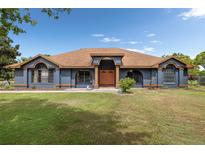 Charming single-story home features a manicured lawn and a welcoming double-door entryway, painted in pleasing blue at 2695 Hilliard Ct, Kissimmee, FL 34744