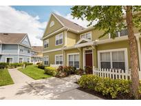 Charming townhome with landscaped front yard and colorful exterior, enhanced by a manicured lawn and inviting walkway at 4008 San Sebastian Dr # 105, Kissimmee, FL 34741