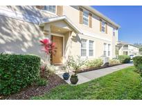 Charming townhouse with a well-maintained front yard, colorful plants, and a welcoming entryway at 7110 Red Lantern Dr # 23, Harmony, FL 34773