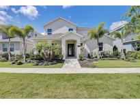 Stunning two-story home with lush landscaping and inviting entrance in a tropical setting at 7458 Gathering Dr, Kissimmee, FL 34747