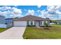 Charming single-story home featuring a well-manicured lawn and attached two-car garage at 761 Parrot Ct, Kissimmee, FL 34759