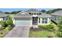 Charming single-story home featuring a two-car garage, brick paved drive, and manicured landscaping at 7834 Stoney Bay Loop, Kissimmee, FL 34747