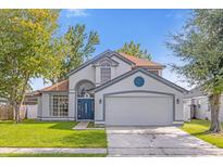 Charming two-story home with a well-manicured lawn and a two car garage at 10957 Norcross Cir, Orlando, FL 32825