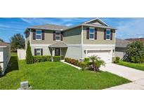 Charming two-story home with a well-manicured lawn, two-car garage, and inviting front entrance at 454 Sunfish Dr, Winter Haven, FL 33881