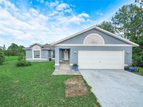 Charming single-story home with a two-car garage and a well-maintained lawn at 739 Paris Dr, Kissimmee, FL 34759