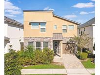 Beautiful two-story home featuring a modern design, well-maintained lawn, and a charming brick driveway at 8937 Amelia Downs Trl, Kissimmee, FL 34747