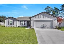 Charming single-story home with a well-manicured lawn, gray siding, and an attached two-car garage at 2722 Sw 151St Pl, Ocala, FL 34473
