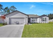 Charming single-story home featuring a well-manicured lawn and a two-car garage at 2645 Sw 163Rd Pl, Ocala, FL 34473