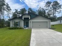Charming single-Gathering home featuring a two-car garage, landscaped lawn, and inviting front entrance at 5251 Sw 164Th Street Rd, Ocala, FL 34473