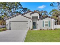 Charming one-story home featuring a two-car garage and a beautifully maintained front yard at 15271 Sw 65Th Terrace Rd, Ocala, FL 34473
