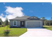 Charming single-story home featuring a two-car garage, well-manicured lawn, and modern architectural details at 431 Caribbean Ct, Poinciana, FL 34759