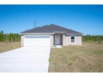 New single-Gathering home with a gray roof, white garage, and long concrete driveway at 2700 Laguna Dr, Indian Lake Estates, FL 33855