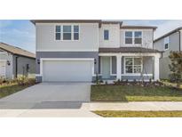 Two-story home with gray siding, a light green door, and a two-car garage at 4390 Sw 84Th Street Rd, Ocala, FL 34476