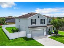 Two-story house with gray siding, a two-car garage, and a fenced backyard at 1875 Monte Cristo Ln, Kissimmee, FL 34758