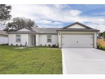 Charming single-story home featuring a two-car garage and a well-manicured lawn at 14945 Sw 38Th Cir, Ocala, FL 34473