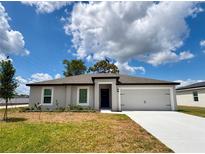Charming single-story home with a well-manicured lawn and a two-car garage at 1 Zinnia E Ln, Poinciana, FL 34759