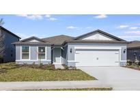 Gray house with two-car garage and landscaped lawn at 6826 Sw 90Th Loop, Ocala, FL 34476