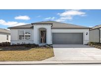 One-story home with gray garage door and landscaping at 6829 Sw 90Th Loop, Ocala, FL 34476