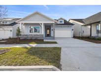 New single-story home with light blue siding, stone accents, and a two-car garage at 3068 Bootlace Way, St Cloud, FL 34771
