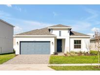 One-story home with gray garage door and landscaped yard at 5783 Greenery Ln, St Cloud, FL 34771