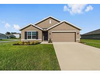 Charming single-Gathering home with a manicured lawn, neat flowerbeds, and a two-car garage at 684 Se 65Th Ter, Ocala, FL 34472