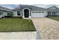 One-story home with a two-car garage, and landscaped lawn at 7987 Lake James Blvd, Lakeland, FL 33810