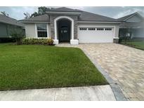 One-story home with a two-car garage and landscaped lawn at 7987 Lake James Blvd, Lakeland, FL 33810