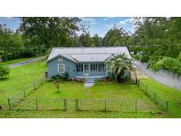Aerial view of a well maintained home featuring a metal roof and a spacious, lush green yard at 323 Nw 25Th St, Ocala, FL 34475
