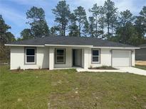 Charming single-story home featuring a well-manicured lawn and neutral exterior paint scheme at 15499 Sw 27Th Ln, Ocala, FL 34481