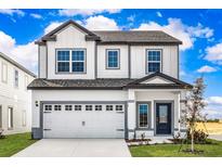 Two-story house with white siding, gray accents, and a two-car garage at 3732 Bergamot St, Lake Alfred, FL 33850