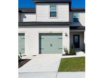 Charming home featuring a light green garage door and a well-maintained, neatly landscaped front yard at 836 Poppy Ln, Dundee, FL 33838